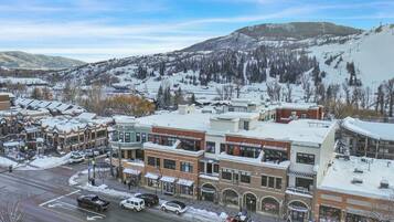 A town with buildings, a road, and a snow-covered mountain in the background.