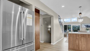 A modern kitchen with stainless steel appliances, wooden cabinetry, and a large island.