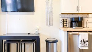 A modern kitchen with a flat-screen TV, a coffee machine, and a trash can. - Aspen Vista Hideaway (Steamboat Springs)