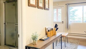 A kitchen with a wooden countertop, a potted plant, and framed botanical prints on the wall. - Aspen Vista Hideaway (Steamboat Springs)