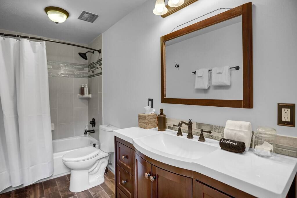 A bathroom with a bathtub, toilet, and sink.