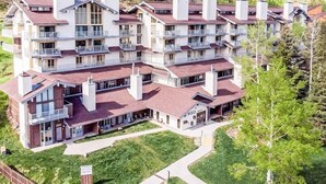 A multi-story hotel with balconies, a central courtyard, and a view of the surrounding landscape. - Slopeside Chalet (Steamboat Springs)