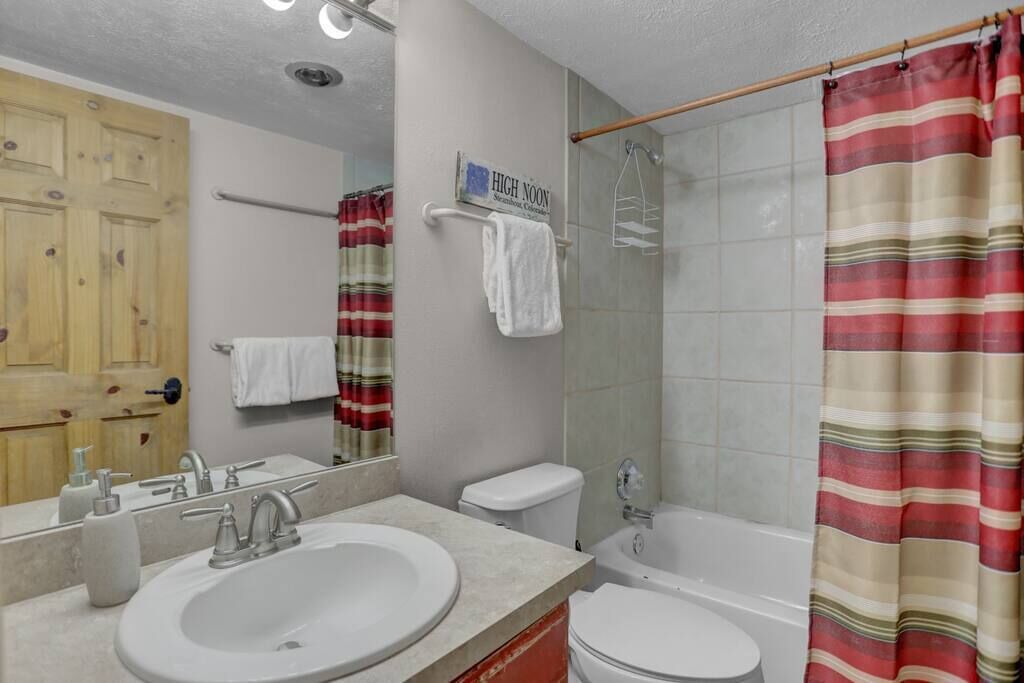 Une salle de bain avec un lavabo, des toilettes et une douche.