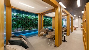 Un espace spa agrémenté d’un mur végétal, d’une petite piscine et de coins salon.