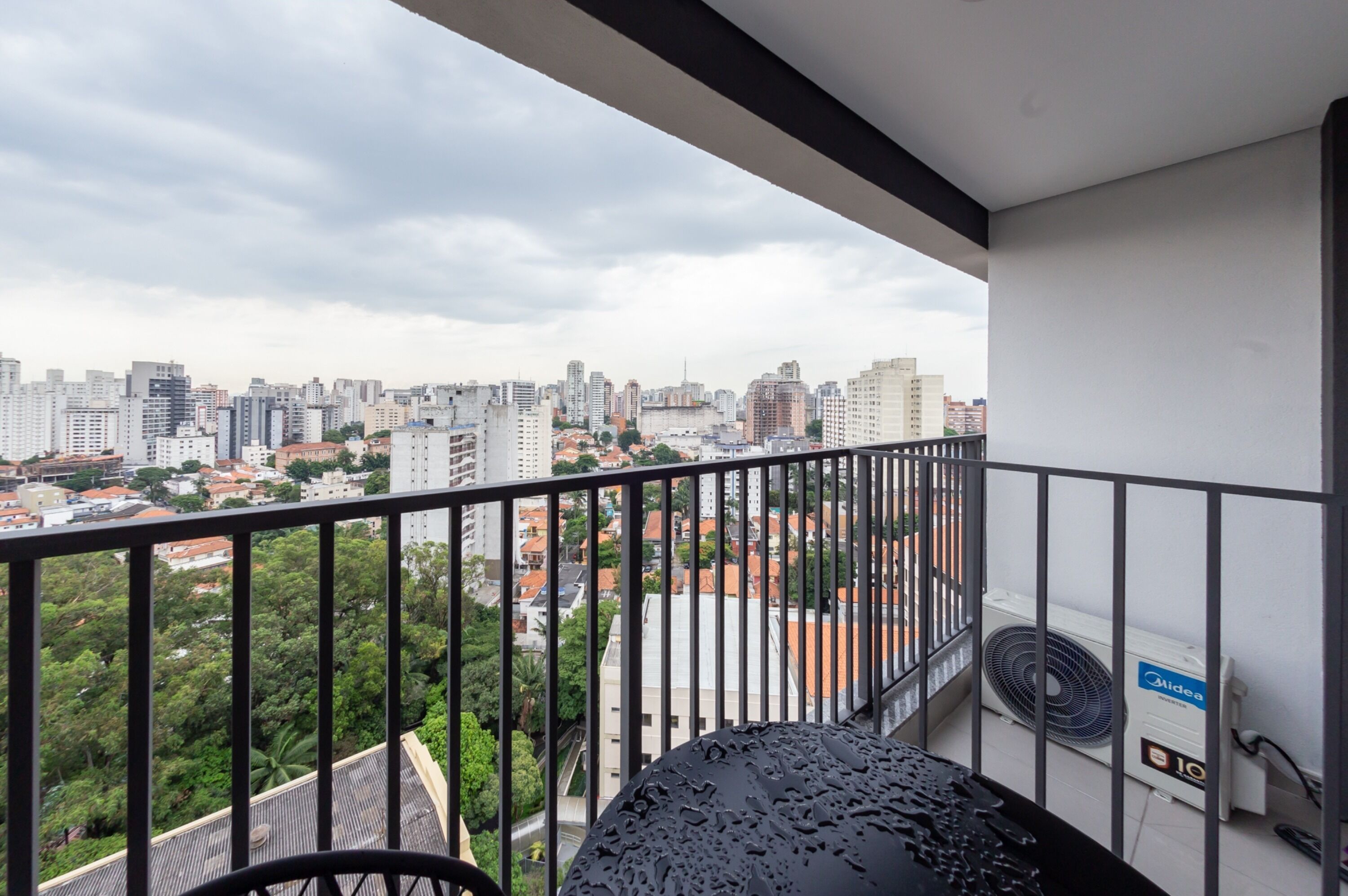 A balcony with a city view, a water heater, and a fan.