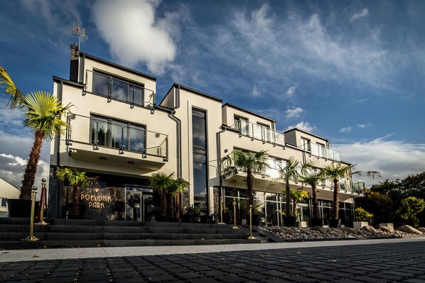 A modern building with a flat roof, large windows, and a sign that reads "POUDNIK PARK". - Południk Park Hotel Conference&SPA (Stargard Szczecinski)