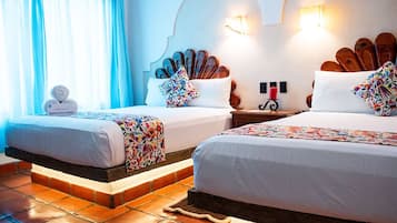 A hotel room with two beds, a tiled floor, and a decorative headboard.