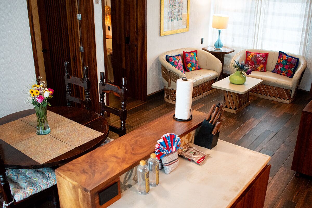 A cozy living area with a wooden dining table, a sofa set, and a coffee table.