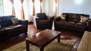 Una sala de estar con dos sofás, una mesa de centro y una alfombra.