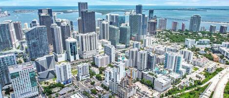 A cityscape with high-rise buildings, roads, and a body of water.