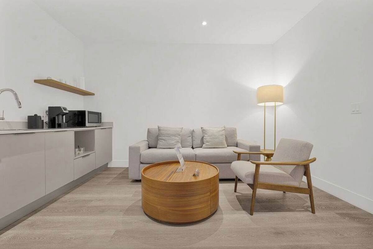 Eine moderne Küche mit Mikrowelle, Kaffeemaschine und einem Holztisch.