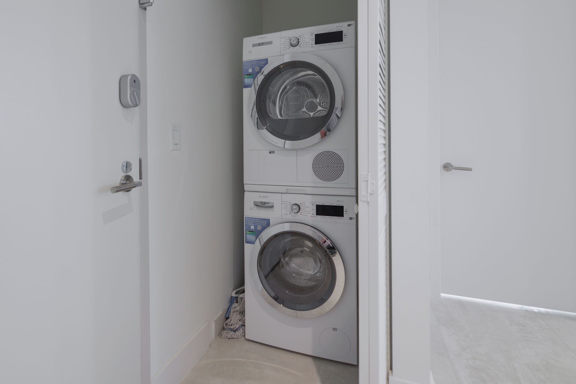 A laundry room with two stacked front-loading washing machines.