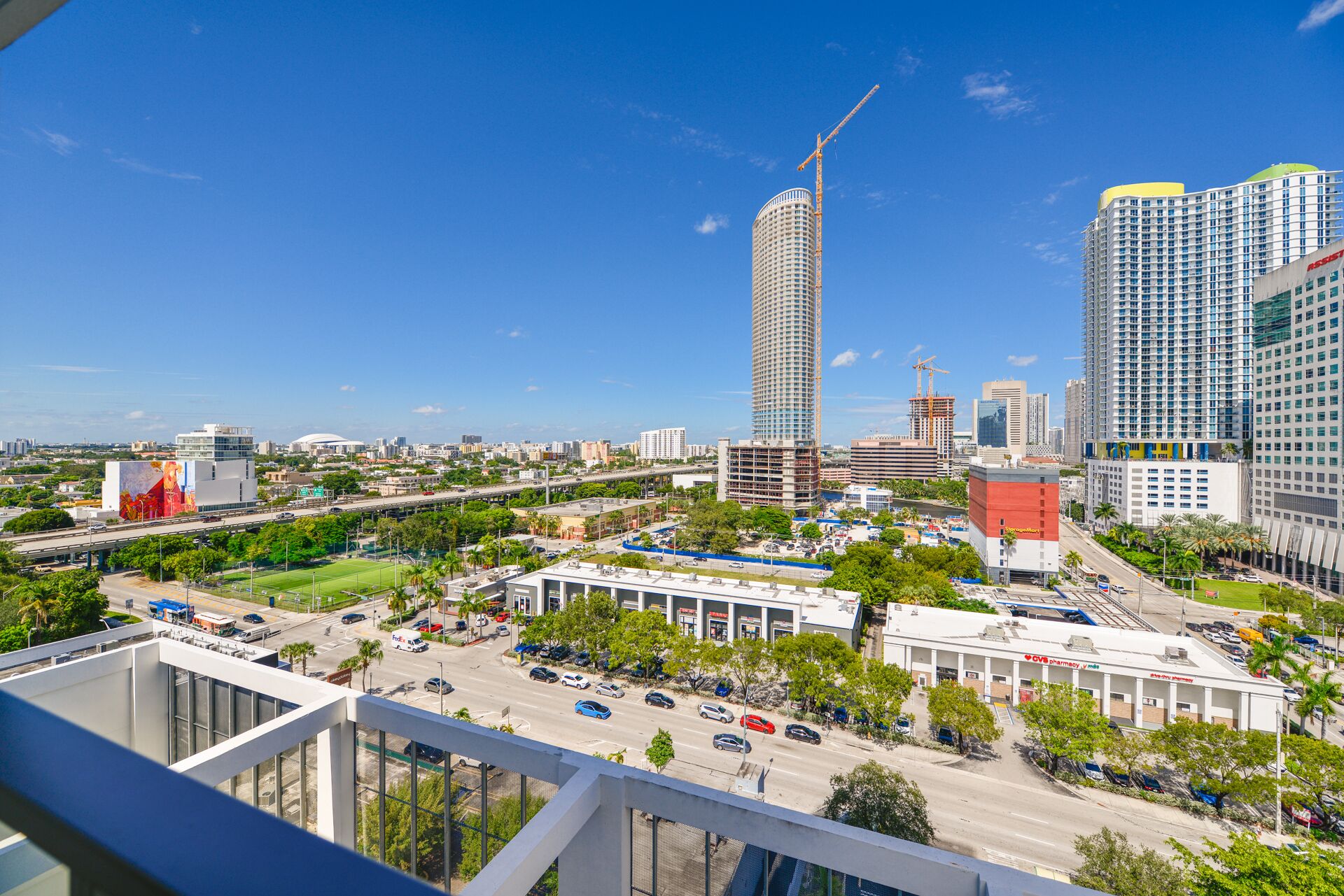 A cityscape with a prominent tall building under construction, a CVS pharmacy, and a parking lot.