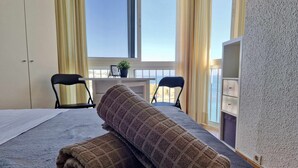 A hotel room with a bed, two chairs, a desk, and a view of the sea. - SR Almirante 1ª Linea de Playa (Mijas)