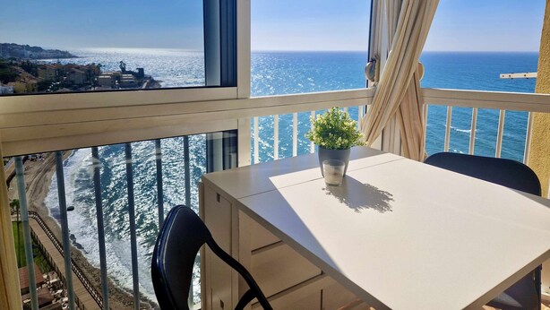 A balcony with a view of the sea, a table with a potted plant, and a chair. - SR Almirante 1ª Linea de Playa (Mijas)