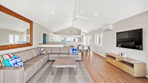 A modern living room with a sectional sofa, a coffee table, and a TV.