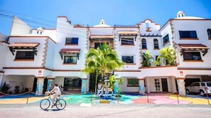 Stylish hotel with a traditional facade, featuring balconies and a parking area.