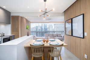 Eine moderne Küche mit Essbereich, Holzvertäfelung und Blick auf die Stadt.