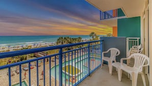 A balcony with a view of the beach and ocean.