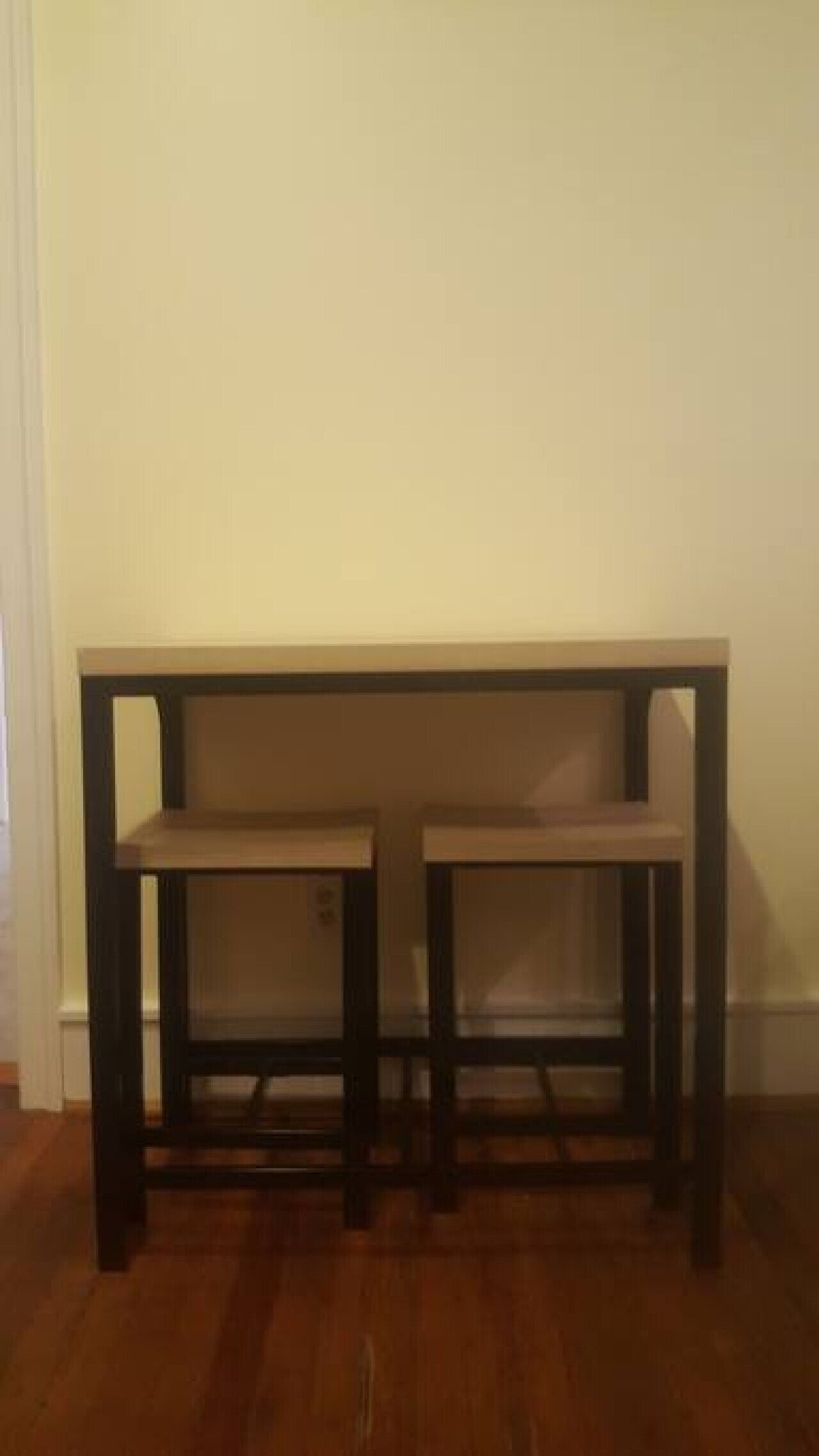 Un banco de madera con dos asientos frente a una pared lisa.