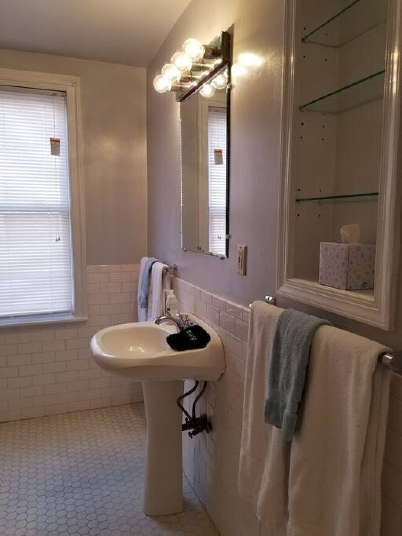A bathroom with a sink, mirror, and towel rack.