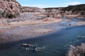 A river flowing through a rocky landscape with sparse vegetation. - Casa Tocaya: Adobe Gem in O'Keeffe country! (Abiquiu)