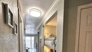 A hallway with a bunk bed, a door, and a light fixture. - Coastal Condo - Beach view, resort (Galveston)