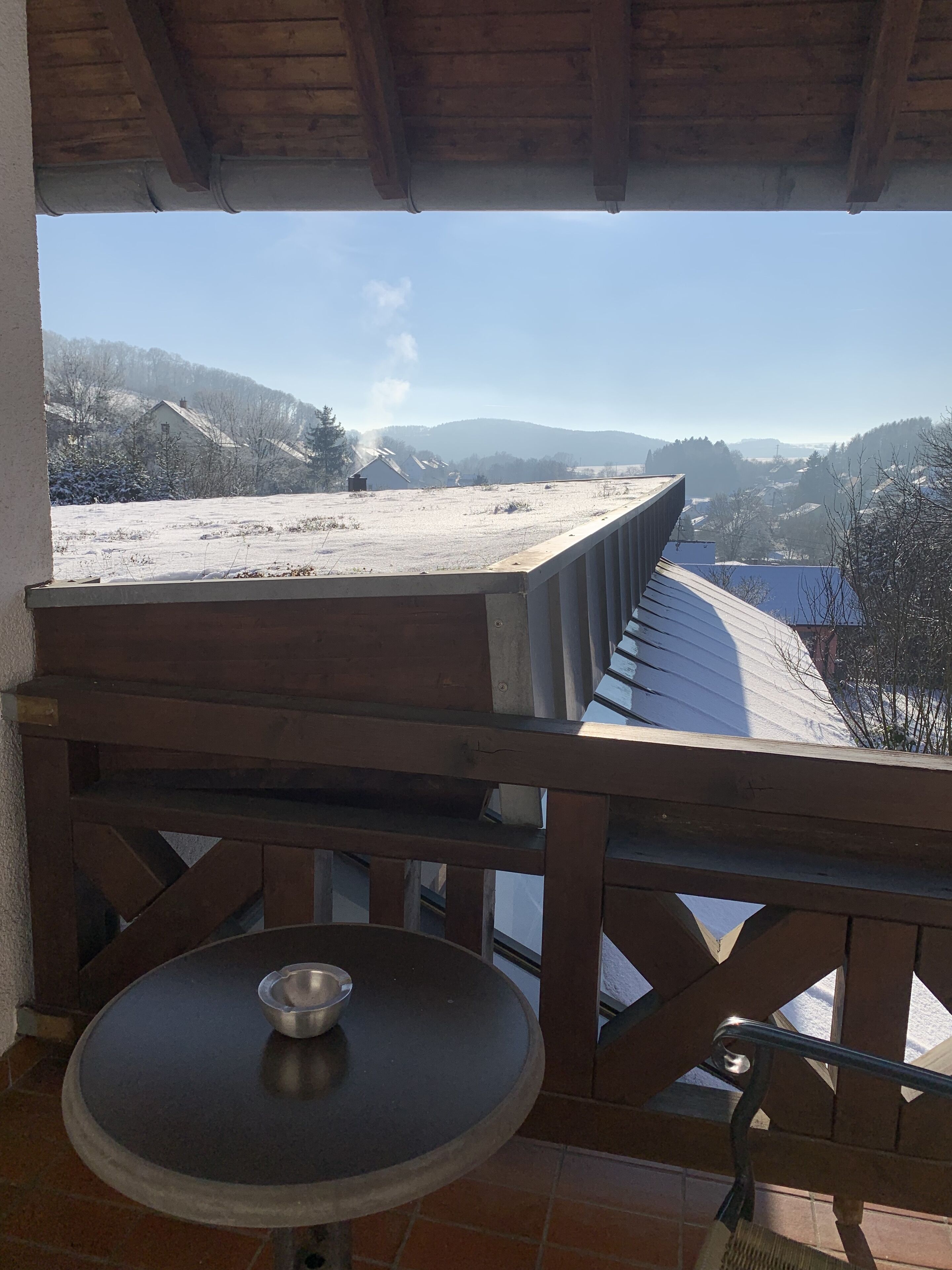 A balcony with a view of a snowy landscape and mountains.