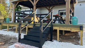 A covered outdoor area with a wooden staircase leading up to a platform. - Peaceful Ocala Home • Fire Pit • 20 Min to World Equestrian Center (Ocala)