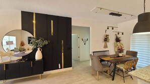 A modern dining area with a black and gold cabinet, a round table, and a large mirror. - Peaceful Ocala Home • Fire Pit • 20 Min to World Equestrian Center (Ocala)