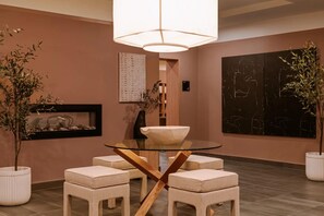 A modern dining area with a glass table, cushioned chairs, a large pendant light, and artwork on the walls. - Arlo, BW Signature Collection (Ottawa)