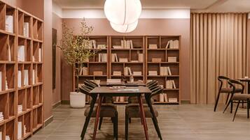 A modern library with a round table and chairs, surrounded by bookshelves.