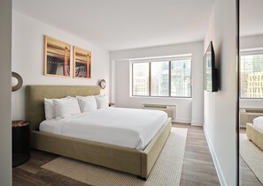 A modern bedroom with a large bed, a window with a city view, and artwork on the wall. - Arlo, BW Signature Collection (Ottawa)