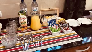 A kitchen counter with various items including bottles, a pitcher, and utensils.