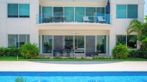 Un edificio moderno de dos pisos con una piscina en frente.