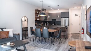 A modern apartment with a dining area, kitchen, and living room. - Mountainview Escape Revelstoke Vacations (Revelstoke)