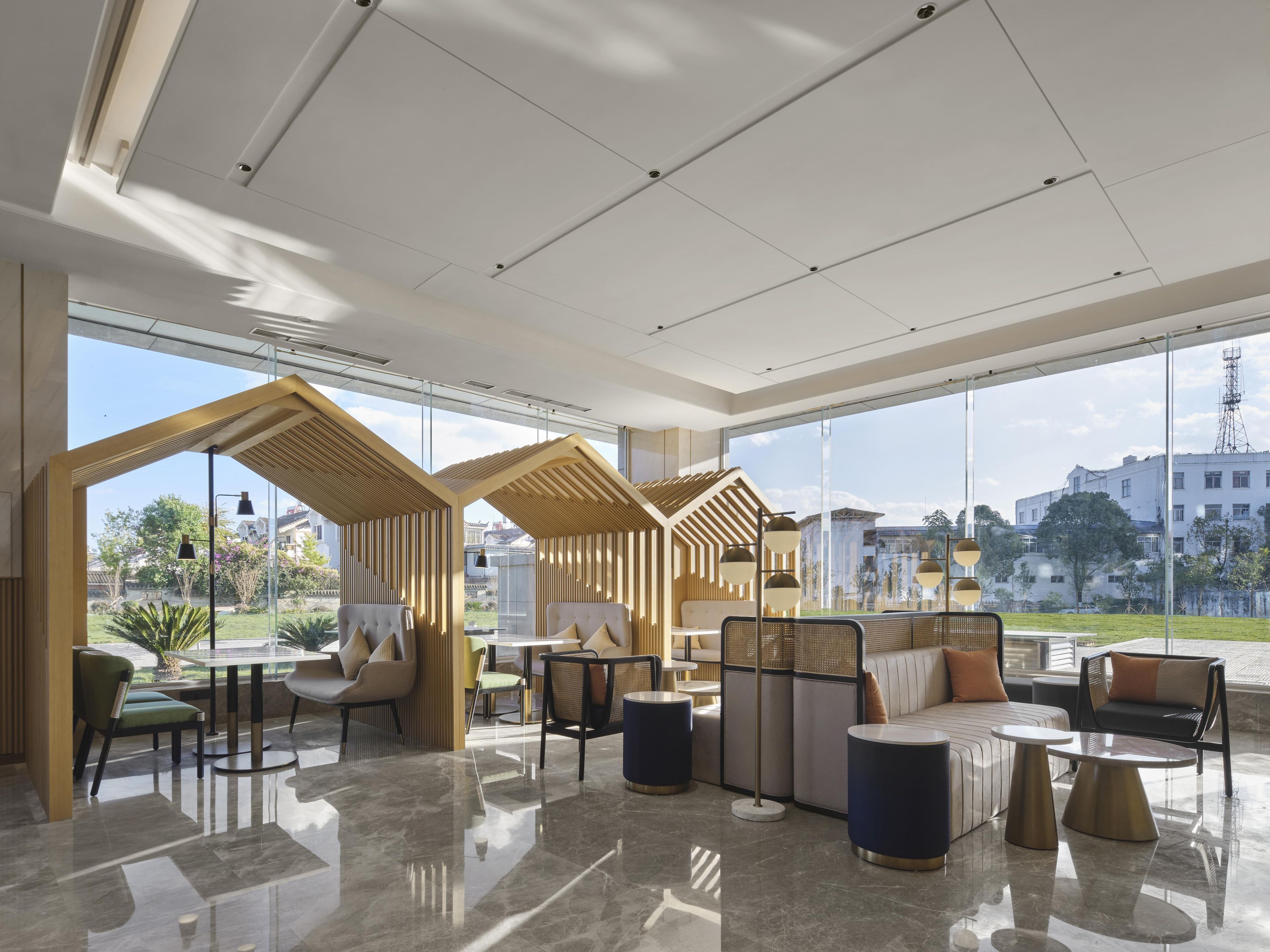 A modern interior with a seating area, tables, and a view of the outside.