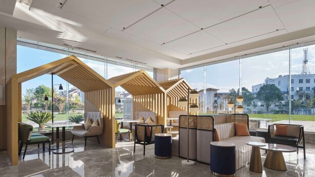 Een moderne lounge met glazen scheiding, comfortabele zitplaatsen en uitzicht op de stad.
