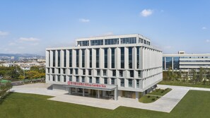 A modern hotel building with a flat roof, large windows, and a sign for Hilton Garden Inn. - Hilton Garden Inn Kunming Dianchi (Kunming)