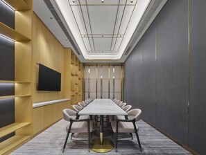 A conference room with a long table, chairs, a flat-screen TV, and a ceiling with recessed lighting. - Hilton Garden Inn Kunming Dianchi (Kunming)