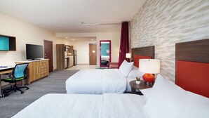 Habitación de hotel con dos camas, un escritorio con silla, televisor y microondas.