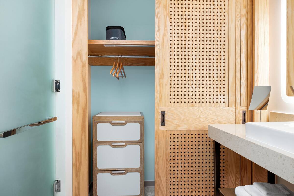 Een badkamer met een houten wastafelmeubel, een wastafel en een handdoekhouder.