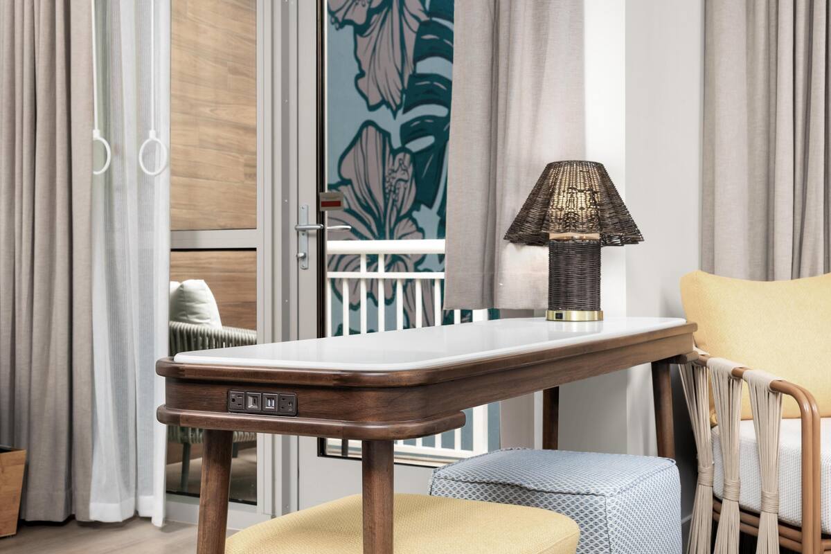 Een moderne kamer met een houten tafel, een lamp en een beklede bank.