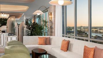 A modern living room with a sofa, two side tables, and a green patterned chair.