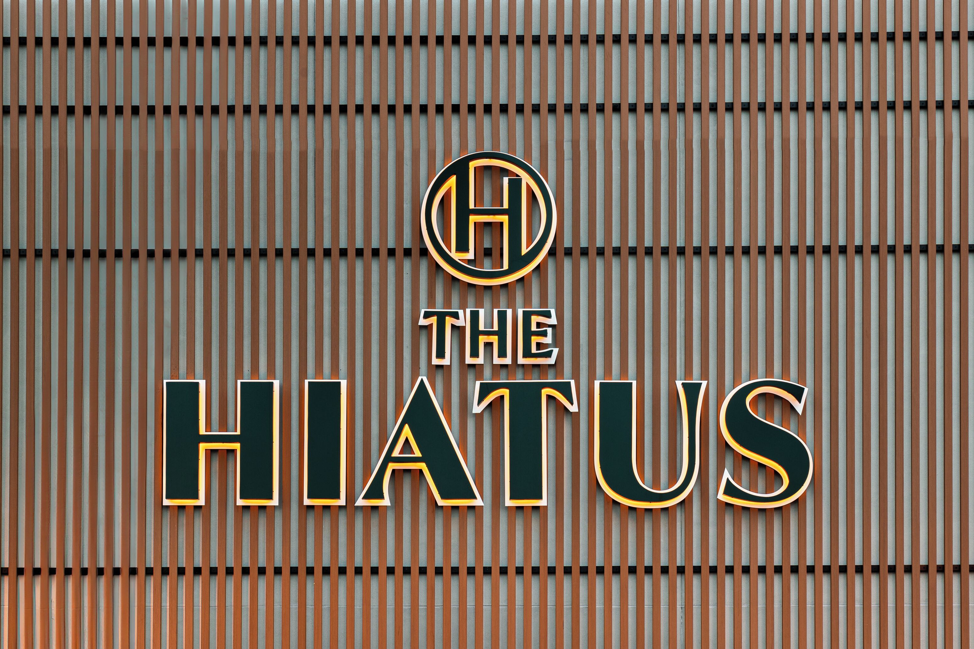 Un letrero de hotel con el nombre 'THE HIATUS' en letras negritas y mayúsculas.