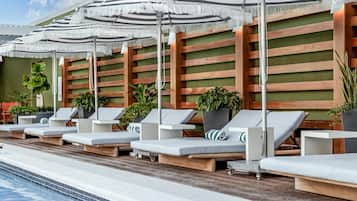 Een buitenzwembad, parasols voor strand/zwembad