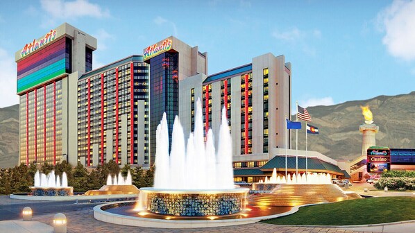 A large hotel with multiple buildings, a central fountain, and flags.