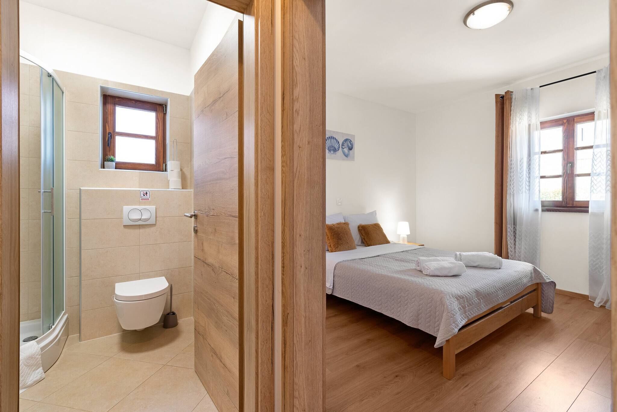 Une chambre à coucher avec un lit, une fenêtre et une salle de bain comprenant des toilettes et une douche.