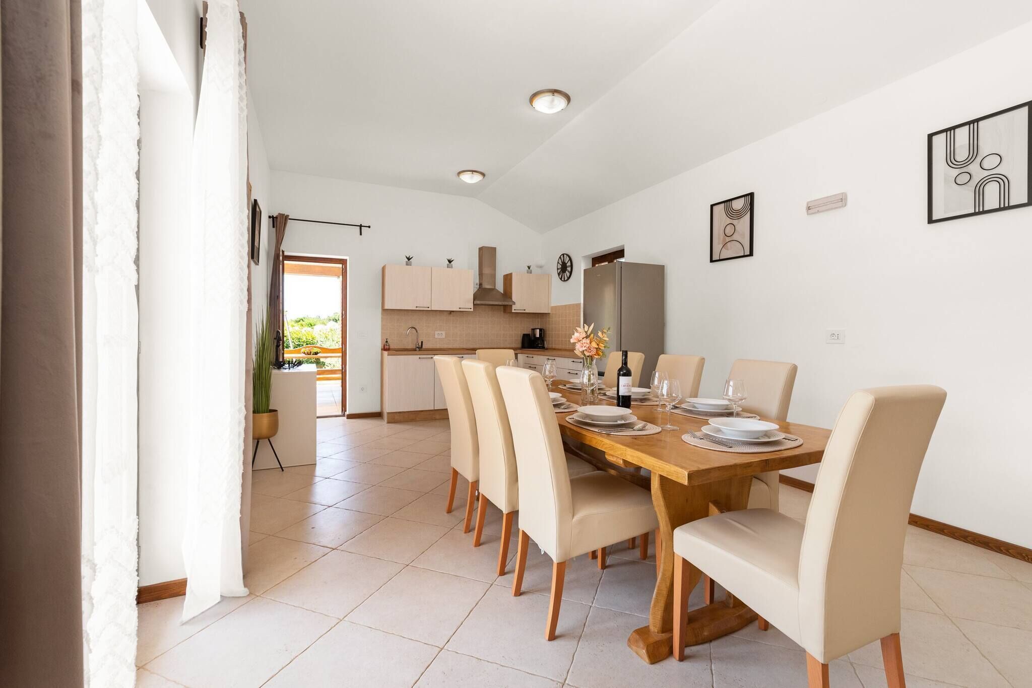 Un espace repas moderne avec une table en bois dressée pour quatre personnes, entourée de chaises de couleur beige.