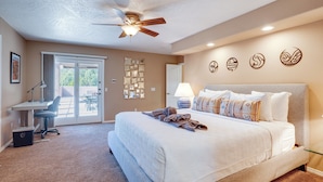 A bedroom with a large bed, a desk, and a ceiling fan. - Covered Deck & Red Rock Views: Home in Sedona (Sedona)